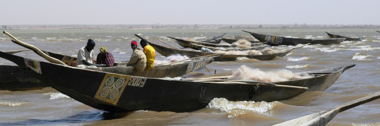 Pirogues de pêcheurs sur un large fleuve.